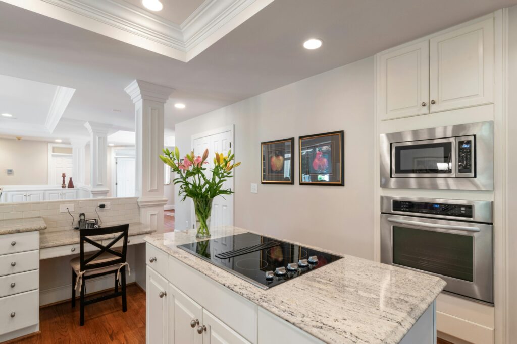 Spacious and elegant kitchen interior featuring granite countertops and built-in appliances.